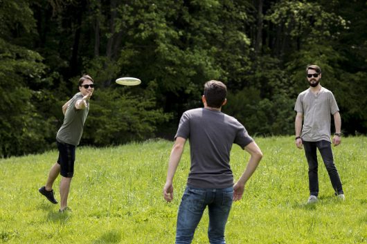 adult-men-resting-park-by-playing-frisbee