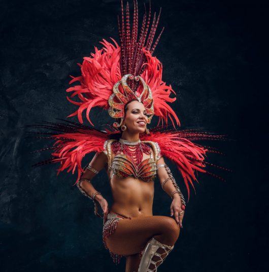 une-jeune-danseuse-bresilienne-attrayante-en-costume-de-plumes-rouges-danse-dans-un-petit-studio-sombre-min