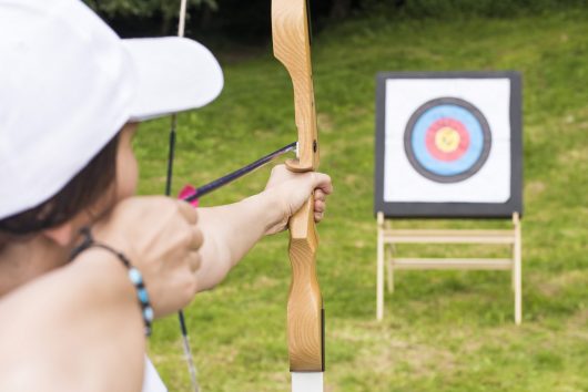 young-female-archer-holding-his-bow-aiming-target-sport-recreation-concept
